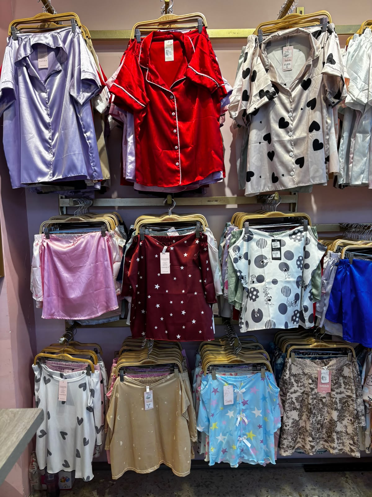 Perchas con pijamas de satín y algodón colgadas en la tienda